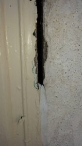 This window joint failed because the materials expanded and contracted over time. Caulk can bridge small movement, but when the gap shifts too much it eventually splits, leaving an opening for air and water to get inside.