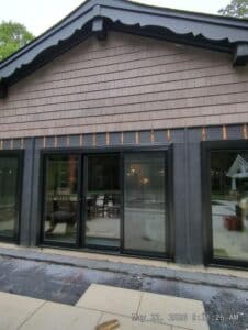 Black siding with black new doors installed on it